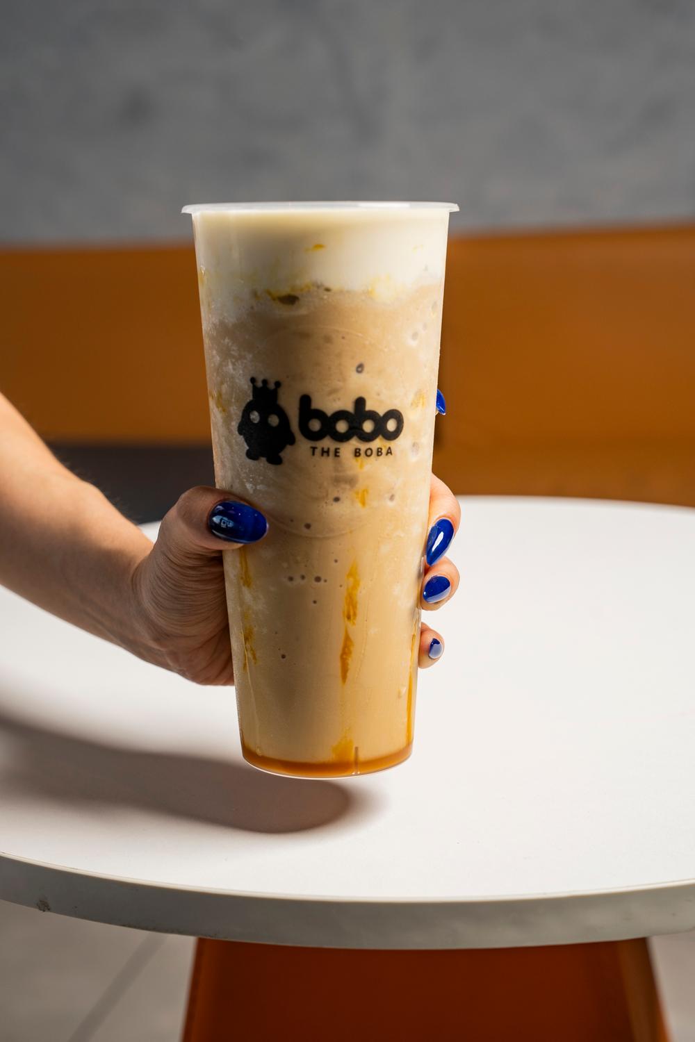 Hand holding a large brown sugar milk tea