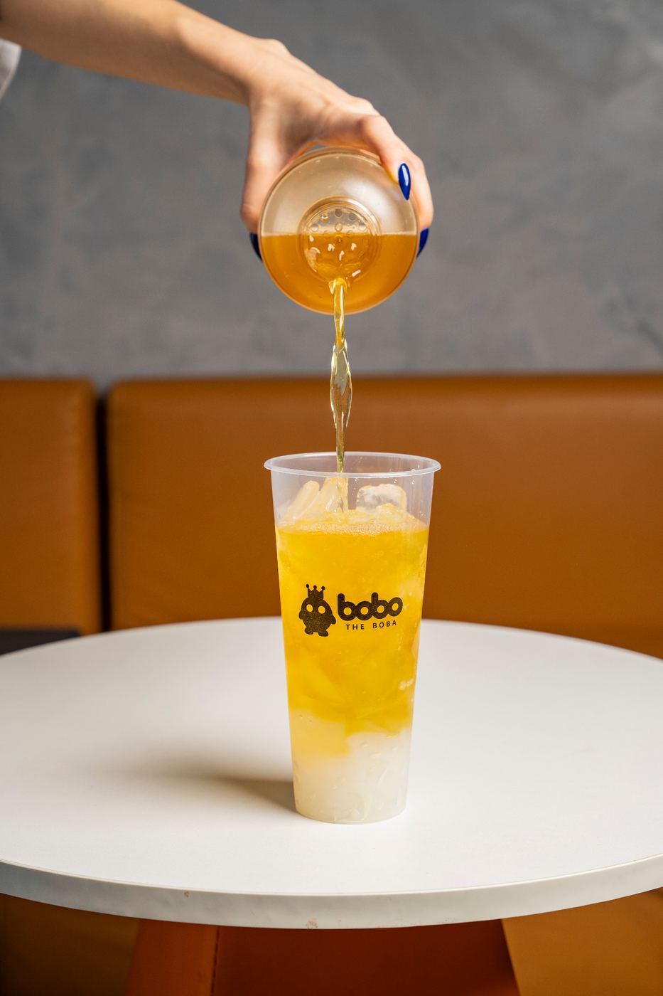 Mango tea being poured into a Bobo cup