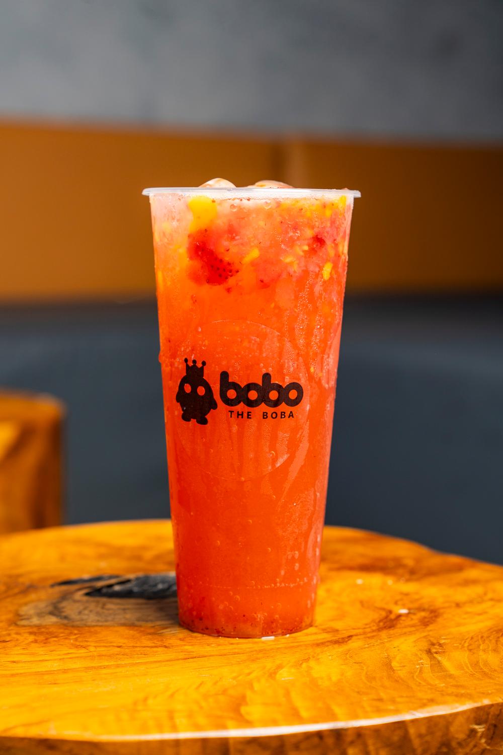 Strawberry mango slush with fresh fruit on a wooden table