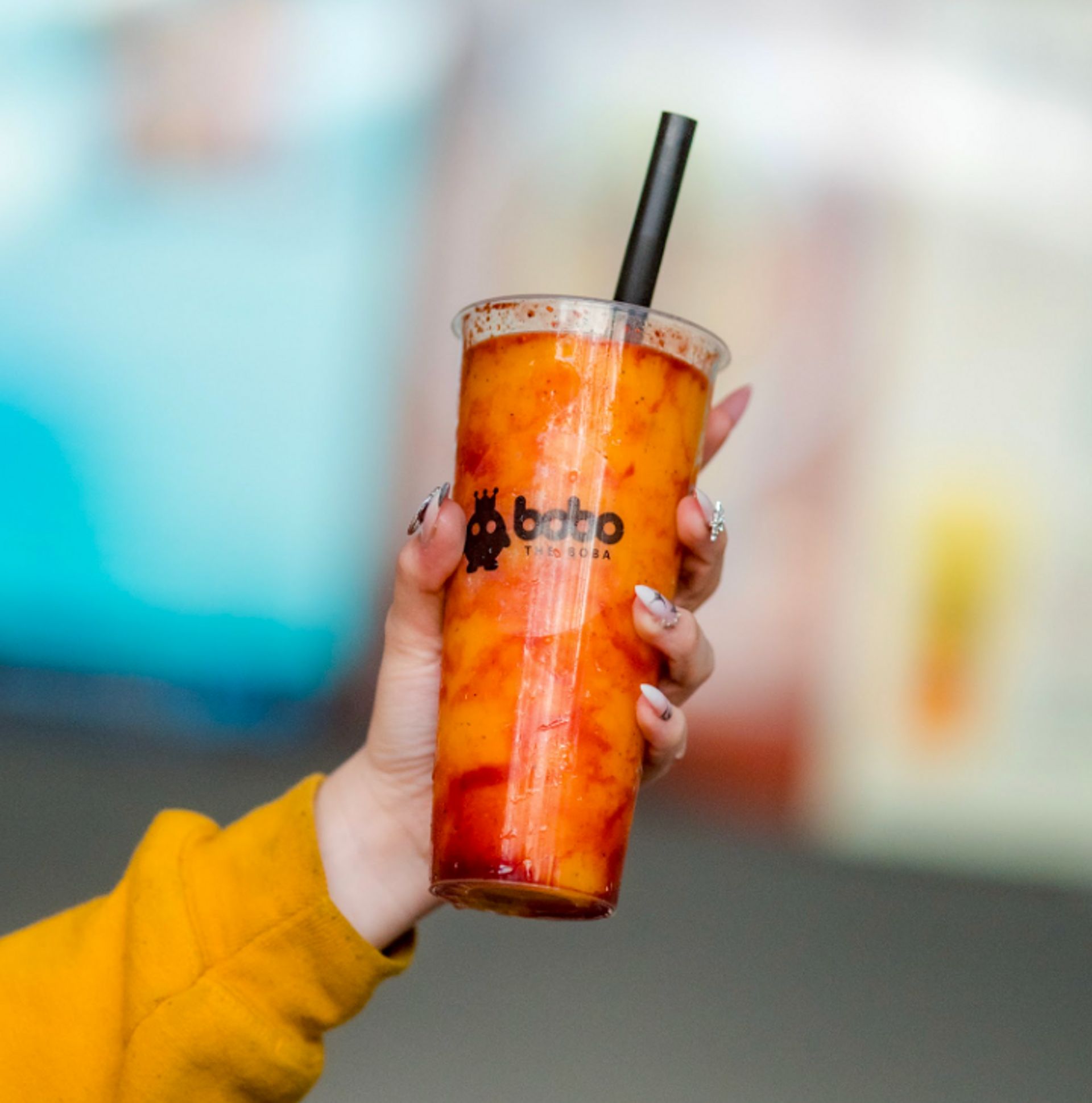 Handheld fruit tea with fresh fruit pieces